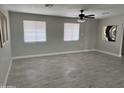 Bright living room featuring tile floors, two windows, a ceiling fan, and neutral paint at 845 N Los Alamos Dr, Goodyear, AZ 85338