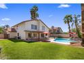 Spacious backyard with lush green lawn, covered patio, pool, spa, and outdoor seating at 9012 E Sutton Dr, Scottsdale, AZ 85260
