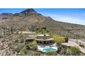 Spectacular aerial view of a modern home with a pool and mountain views in a desert landscape at 11334 E Troon Vista Dr, Scottsdale, AZ 85255