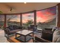 A covered patio featuring plush outdoor seating and stunning sunset views at 11334 E Troon Vista Dr, Scottsdale, AZ 85255