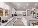 Stunning kitchen with white cabinets, a large island, stainless appliances, and wood-look flooring at 12906 W Oyer Ln, Peoria, AZ 85383
