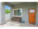Inviting front porch with a wooden bench, gray statue and a decorative front door at 14415 N 184Th Ave, Surprise, AZ 85388