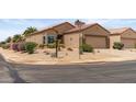 Single-story house on a corner lot with a two-car garage, desert landscaping, and street signs at 16205 W Mountain Pass Dr, Surprise, AZ 85374