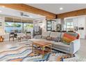 Open-concept living room featuring exposed wood beam, modern furniture, with view into bright, well-appointed kitchen at 1702 W Glenrosa Ave, Phoenix, AZ 85015