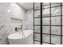 Spa-like bathroom boasts a modern freestanding tub and a glass-enclosed shower with marble tile at 1713 W Palomino Dr, Chandler, AZ 85224