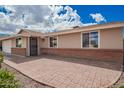 Charming home featuring a brick-accented facade and an inviting front entrance with decorative security door at 1713 W Palomino Dr, Chandler, AZ 85224