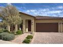 Inviting single-story home featuring a well-manicured front yard and a charming covered entrance at 17211 W Whispering Wind Rd, Surprise, AZ 85387