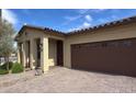 Charming single-story home boasts a brick driveway and a convenient attached two-car garage at 17211 W Whispering Wind Rd, Surprise, AZ 85387