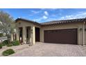 Welcoming home with a tile roof, landscaped front yard, and attached two-car garage at 17211 W Whispering Wind Rd, Surprise, AZ 85387