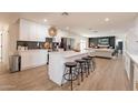 Bright kitchen with island and breakfast bar featuring white cabinetry and modern appliances at 1747 W Echo Ln, Phoenix, AZ 85021
