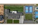 Bird's eye view of an expansive house with tennis and pickleball courts, plus a lush lawn at 18826 E Augusta Ave, Queen Creek, AZ 85142