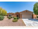 Charming single-story home with a two-car garage, stone accents, and desert landscaping at 19225 N Tallowood Way, Surprise, AZ 85387