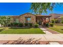 Charming single-story home with stone accents, manicured lawn and covered front porch at 20423 W Springfield St, Buckeye, AZ 85396