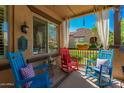 Inviting front porch with rocking chairs, neutral rug, sheer curtains and privacy at 20423 W Springfield St, Buckeye, AZ 85396