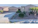 Charming home with a low-maintenance front yard, desert landscaping, and ample driveway space at 20581 N Enchantment Pass, Maricopa, AZ 85138