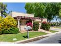 Inviting home with vibrant yellow and pink flowers framing the entrance and lush green lawn, showcasing a well-cared-for exterior at 2322 S Rogers -- # 1, Mesa, AZ 85202