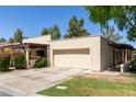 Exterior shot of this beautiful house featuring a two-car garage, manicured lawn, and an appealing neutral color palette at 2322 S Rogers -- # 1, Mesa, AZ 85202