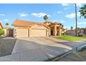 Charming single-story home featuring a three-car garage, desert landscaping, and a tile roof at 3295 S Ambrosia Dr, Chandler, AZ 85248