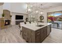 Open concept kitchen features a large island, modern lighting, and fireplace views at 3641 E Los Gatos Dr, Phoenix, AZ 85050