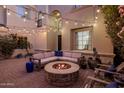Cozy backyard patio with a stone fire pit and comfortable seating under string lights at 3641 E Los Gatos Dr, Phoenix, AZ 85050