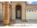Close-up of the front door framed by an archway, desert landscaping, and a two-car garage at 3711 E Long Lake Rd, Phoenix, AZ 85048