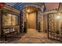 Charming stone archway leading to front door, bench seating, and decorative greenery at 3754 E Flintlock Dr, Queen Creek, AZ 85142