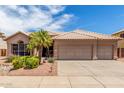 Charming single-story home with a three-car garage, desert landscaping, and a tile roof at 411 N Cordoba Pl, Chandler, AZ 85226
