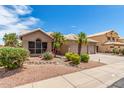 Attractive single-story home featuring desert landscaping, a tile roof, and a three-car garage at 411 N Cordoba Pl, Chandler, AZ 85226