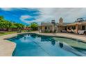 Inviting backyard pool with lounging area, mature trees, and partially covered patio perfect for outdoor relaxation at 4317 E Yucca St, Phoenix, AZ 85028