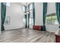 A spacious living room features high ceilings, large windows with dramatic curtains, and wood-look floors at 4413 E Odessa Dr, San Tan Valley, AZ 85140