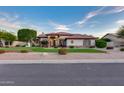 Charming single-story home featuring a brick-accented facade, well-manicured lawn, and mature landscaping at 4637 W Misty Willow Ln, Glendale, AZ 85310