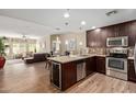 Open concept kitchen with stainless steel appliances, dark wood cabinetry, and a cozy breakfast bar at 5450 E Deer Valley Dr # 1195, Phoenix, AZ 85054