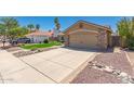 Spacious driveway leading to a two-car garage, enhanced by rock and brick landscaping at 7185 W Kimberly Way, Glendale, AZ 85308
