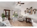Bright living room with hardwood floors, stylish furniture, and sliding glass doors to the backyard at 7185 W Kimberly Way, Glendale, AZ 85308