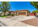 Tan single-story house with mature landscaping, a two-car garage, and a tile roof at 7236 W Aurora Dr, Glendale, AZ 85308