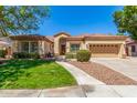 Well-manicured single-story home with mature trees, a tile roof and a two-car garage at 7236 W Aurora Dr, Glendale, AZ 85308