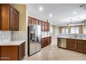 Spacious kitchen featuring stainless steel appliances, rich wood cabinetry, and bright countertops at 9165 W Mine Trl, Peoria, AZ 85383
