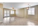 Bright and airy living room with tile and wood flooring, ceiling fan, and elegant light fixture at 9165 W Mine Trl, Peoria, AZ 85383