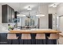 Modern kitchen showcasing dark cabinets, a white marble countertop, and stylish pendant lighting at 10335 E Morning Star Dr, Scottsdale, AZ 85255
