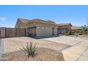 Spacious driveway and three-car garage complemented by a well-kept yard and mature desert landscaping at 11013 E Decatur St, Mesa, AZ 85207