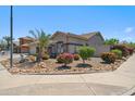 Well-landscaped home exterior featuring desert flora and an American flag at 11013 E Decatur St, Mesa, AZ 85207