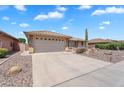 A home with a two-car garage and a desert rock garden in the front at 11040 E Nichols Ave, Mesa, AZ 85209