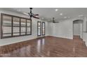 Bright living room boasts hardwood floors, ceiling fans, and plantation shutters at 11040 E Nichols Ave, Mesa, AZ 85209