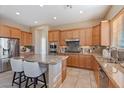 Well-equipped kitchen featuring granite countertops, wood cabinetry, stainless steel appliances, and tile flooring at 12820 W La Vina Dr, Sun City West, AZ 85375