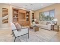 Cozy living room with built-in shelving, a large window, comfortable seating, and contemporary decor at 12820 W La Vina Dr, Sun City West, AZ 85375