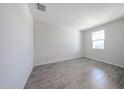 Bright bedroom featuring wood-style tile flooring and a window for natural light at 18219 W Daley Ln, Surprise, AZ 85387