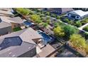 An aerial view showcasing the backyard oasis with pool, green spaces, and patio at 24042 N 170Th Ln, Surprise, AZ 85387