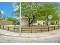 Corner lot featuring desert landscaping, mature trees, and a rustic fence at 2901 W Mandalay Ln, Phoenix, AZ 85053