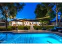 Inviting backyard with a sparkling pool, lush lawn, and charming string lights for relaxed outdoor living at 3027 W Wescott Dr, Phoenix, AZ 85027