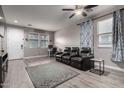 Bright living room with hardwood floors, contemporary furnishings, ceiling fan, and a cozy seating area at 3432 E Bartlett Dr, Gilbert, AZ 85234